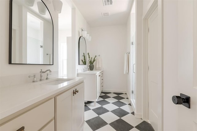 bathroom featuring tile patterned floors, two vanities, visible vents, and a sink