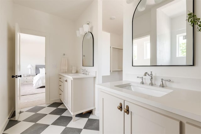 ensuite bathroom featuring a sink, ensuite bathroom, two vanities, and tile patterned floors