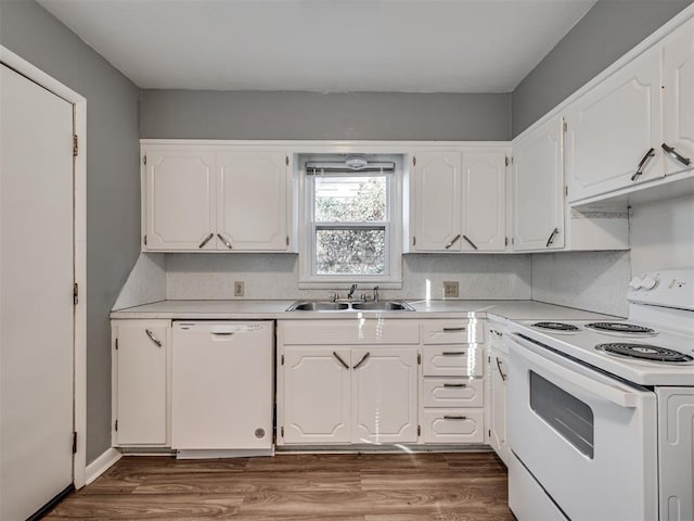 kitchen featuring white cabinetry, sink, white appliances, and hardwood / wood-style flooring