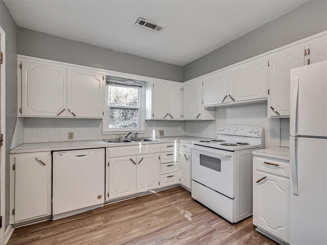 kitchen featuring white appliances, white cabinetry, and sink