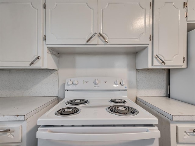 kitchen featuring tasteful backsplash, white cabinetry, and white electric stove