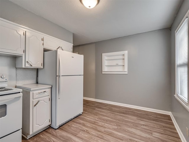 kitchen with built in features, white cabinets, light hardwood / wood-style floors, and white appliances