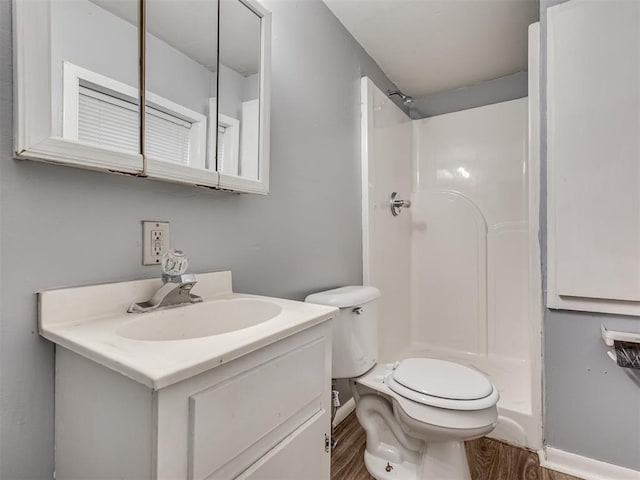 bathroom featuring vanity, toilet, wood-type flooring, and walk in shower