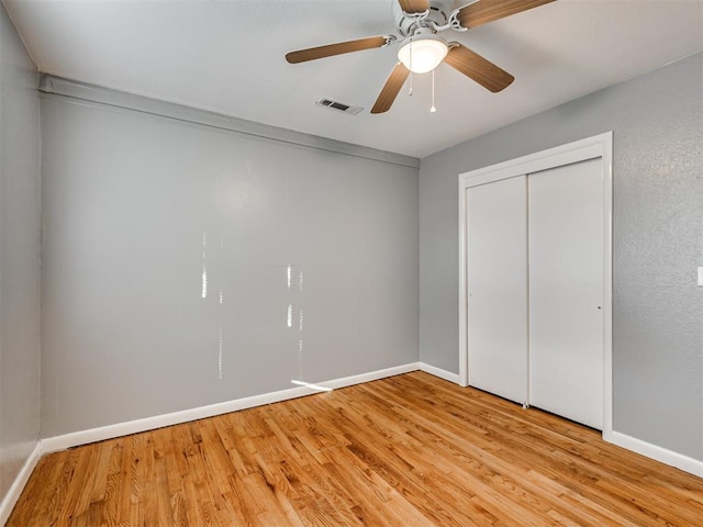 unfurnished bedroom featuring ceiling fan, a closet, and light hardwood / wood-style flooring