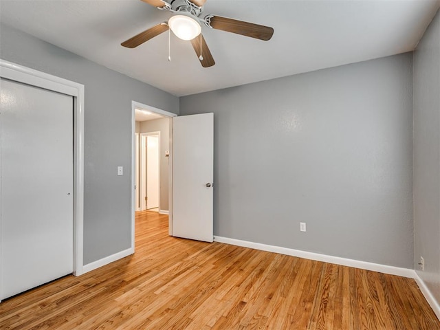 unfurnished bedroom featuring a closet, light hardwood / wood-style flooring, and ceiling fan