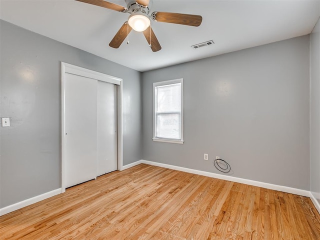 unfurnished bedroom with ceiling fan, a closet, and light hardwood / wood-style floors