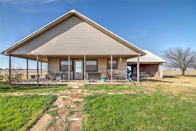 rear view of property featuring a yard