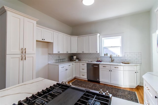 kitchen featuring sink, white cabinets, tasteful backsplash, and dishwasher