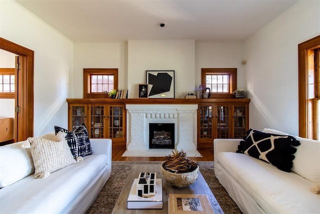 living room featuring a brick fireplace and wood-type flooring