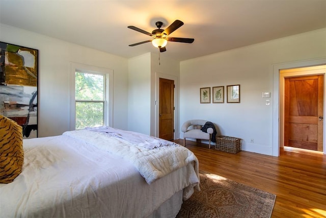 bedroom featuring hardwood / wood-style flooring, ceiling fan, and crown molding