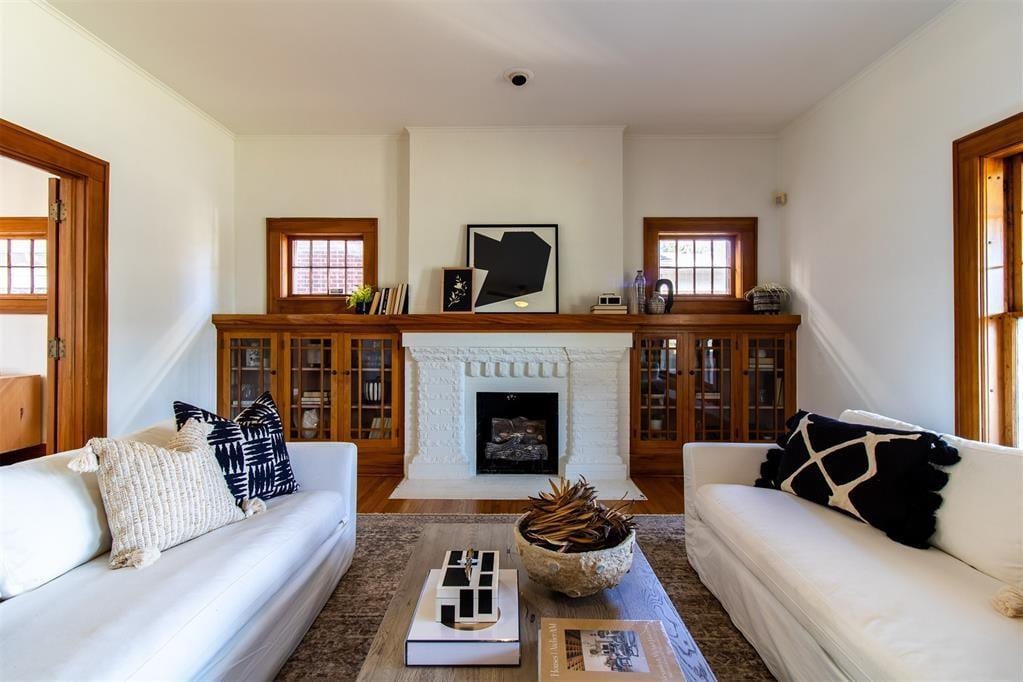 705 NE 14th St, Oklahoma City, OK 73104 - living area featuring a wealth of natural light, crown molding, wood finished floors, and a fireplace