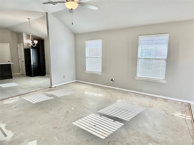 spare room with ceiling fan with notable chandelier and lofted ceiling