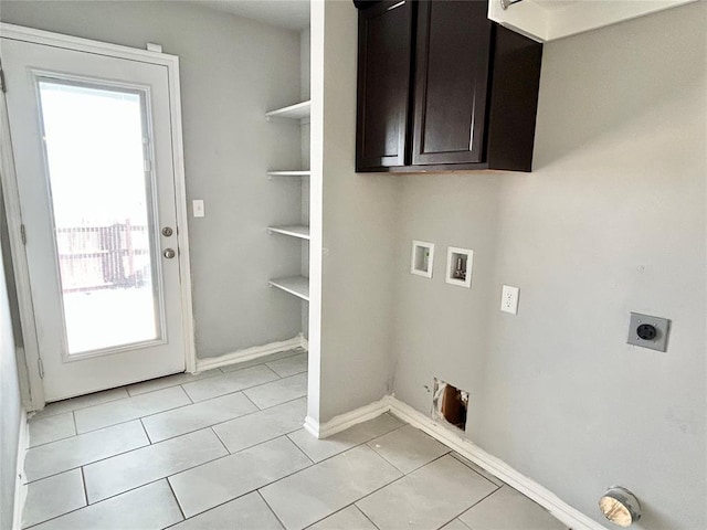 clothes washing area featuring cabinets, electric dryer hookup, gas dryer hookup, hookup for a washing machine, and light tile patterned floors