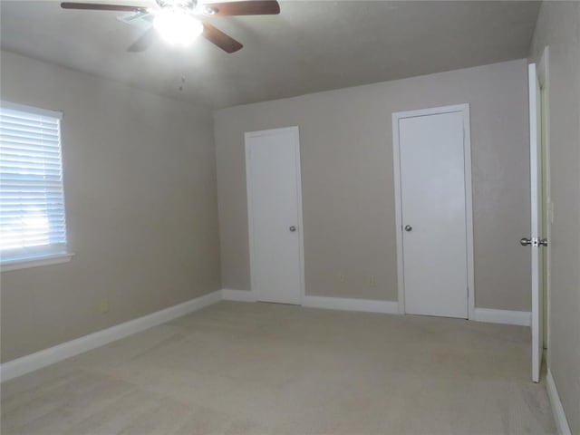 carpeted spare room featuring ceiling fan