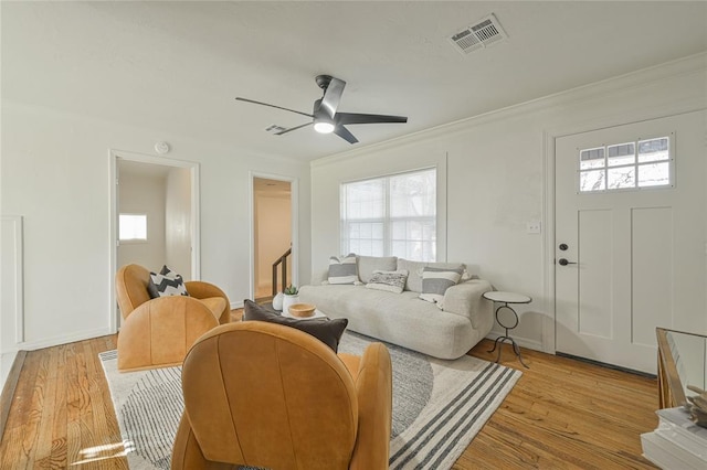 living room featuring ceiling fan, light hardwood / wood-style floors, plenty of natural light, and crown molding