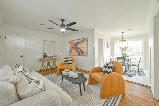 living room with crown molding, ceiling fan, and light hardwood / wood-style floors