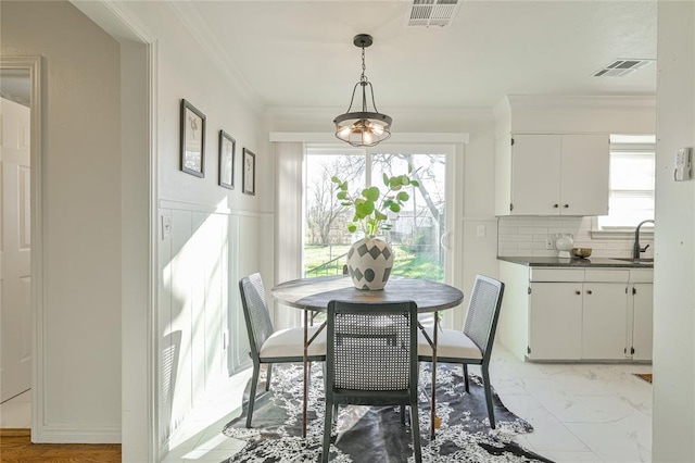 dining room with ornamental molding and sink