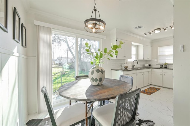 dining space with a chandelier and sink