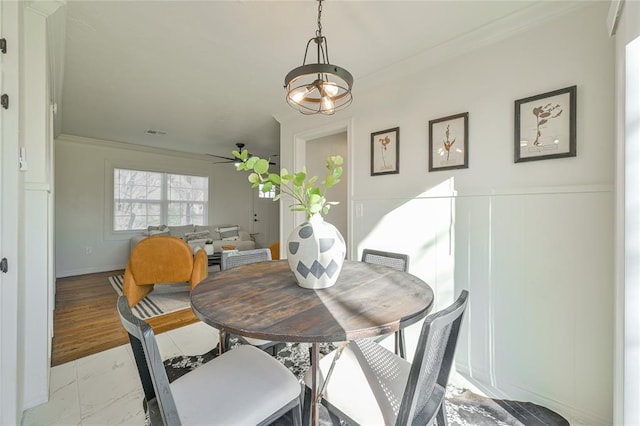 dining space featuring ceiling fan with notable chandelier and crown molding