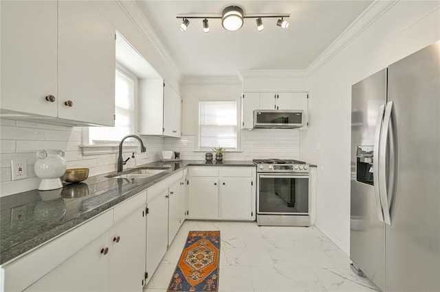 kitchen with white cabinets, appliances with stainless steel finishes, backsplash, and sink