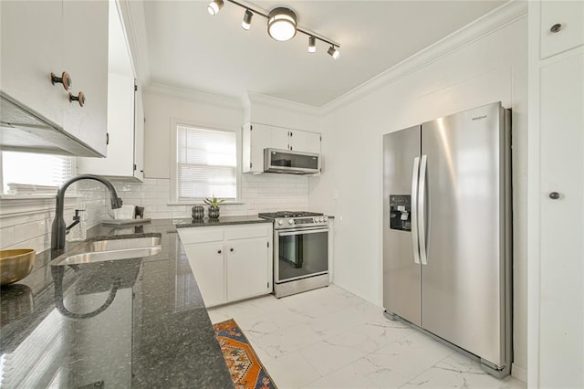 kitchen with backsplash, dark stone counters, white cabinets, sink, and appliances with stainless steel finishes