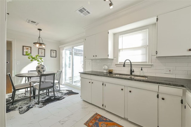 kitchen with white cabinets, decorative light fixtures, and sink