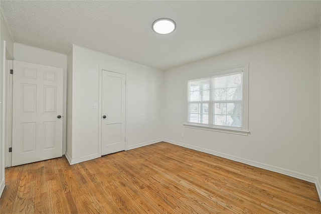 unfurnished bedroom with a closet, a textured ceiling, and light wood-type flooring