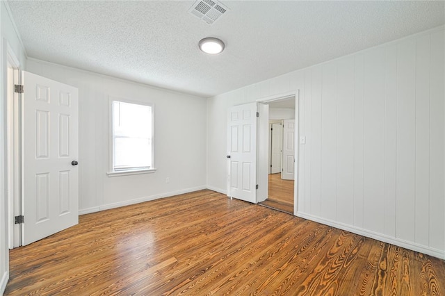 unfurnished bedroom with wood-type flooring and a textured ceiling