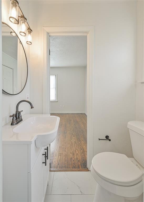 bathroom featuring vanity, toilet, and a textured ceiling