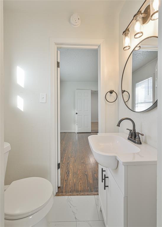 bathroom with vanity, a textured ceiling, and toilet