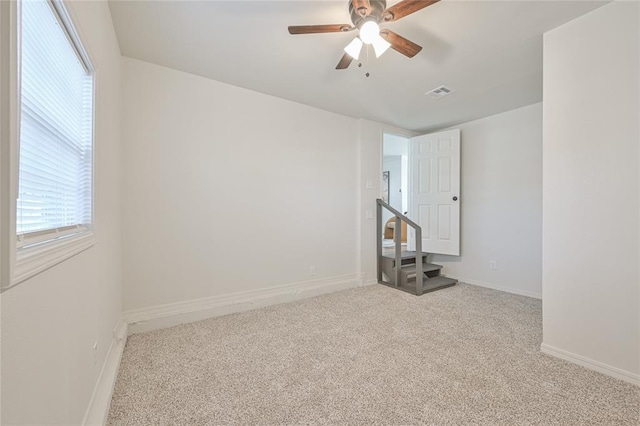 carpeted empty room featuring ceiling fan