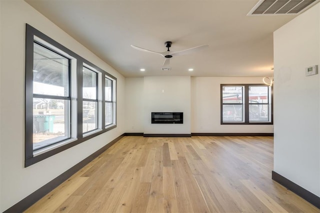 unfurnished living room featuring light hardwood / wood-style flooring, plenty of natural light, and ceiling fan