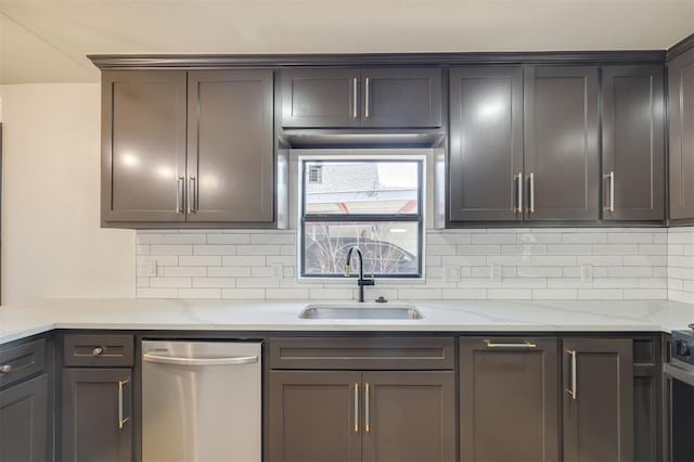 kitchen featuring tasteful backsplash, light stone counters, dishwasher, and sink