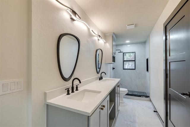 bathroom with vanity, toilet, and a tile shower