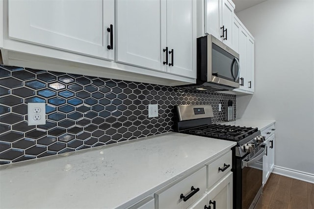 kitchen featuring light stone countertops, appliances with stainless steel finishes, backsplash, dark wood-type flooring, and white cabinetry