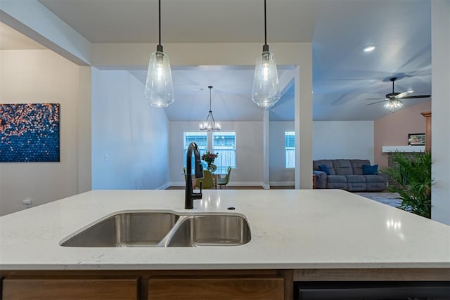 kitchen with a kitchen island with sink, sink, and decorative light fixtures