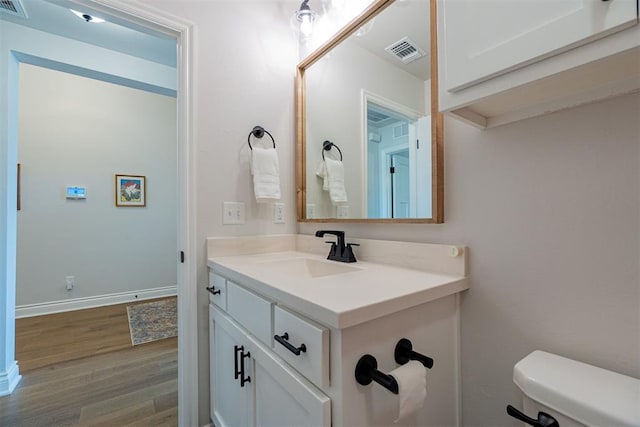 bathroom featuring hardwood / wood-style flooring, vanity, and toilet