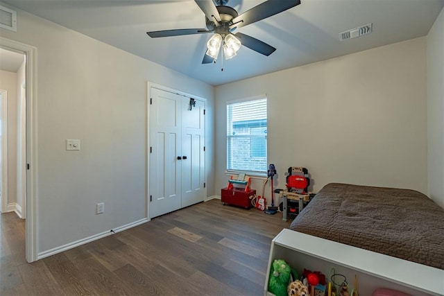 bedroom with dark hardwood / wood-style flooring, a closet, and ceiling fan