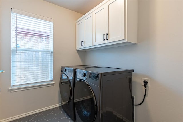 washroom with washer and clothes dryer, cabinets, and dark tile patterned flooring