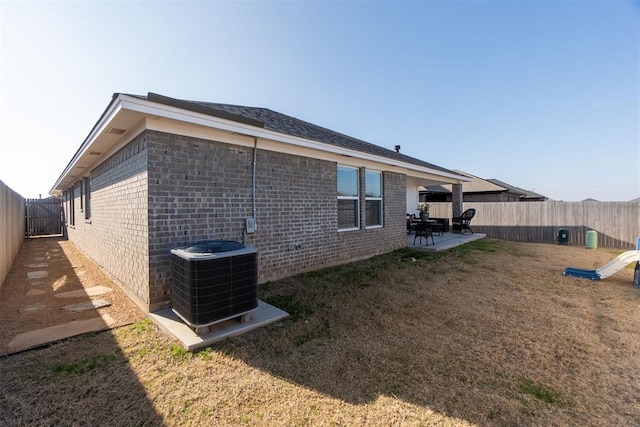 view of side of home with central AC, a patio area, and a yard