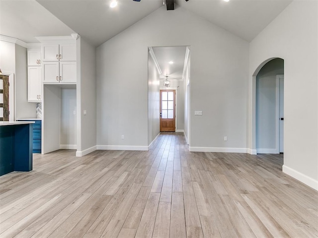 unfurnished living room featuring vaulted ceiling with beams, ceiling fan, and light wood-type flooring