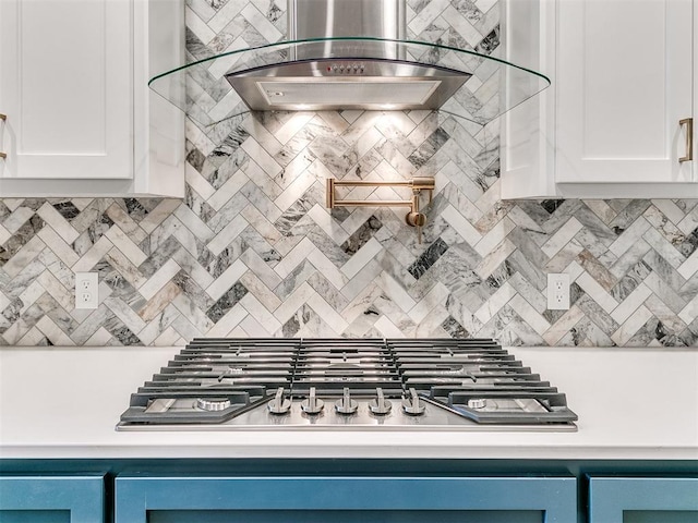 kitchen featuring white cabinets, tasteful backsplash, stainless steel gas cooktop, and wall chimney exhaust hood