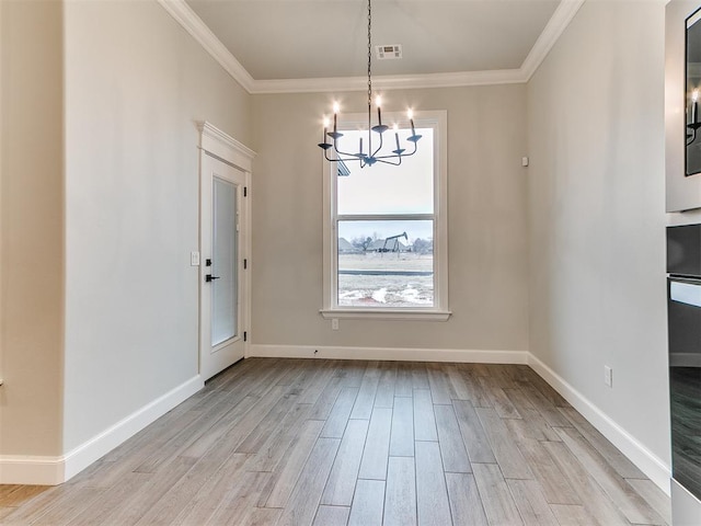 unfurnished dining area with light wood-type flooring, crown molding, and an inviting chandelier