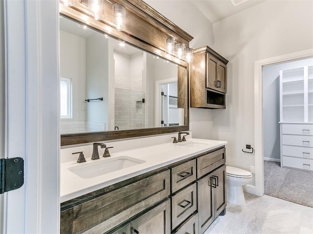 bathroom featuring vanity, a shower with shower door, and toilet