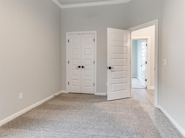 unfurnished bedroom with light carpet, a closet, and ornamental molding