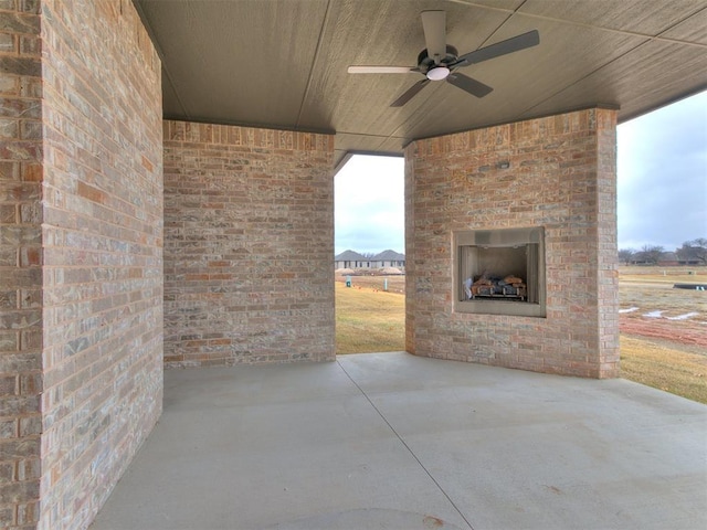 view of patio / terrace featuring an outdoor brick fireplace and ceiling fan