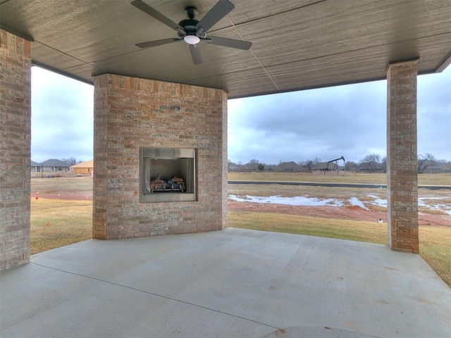 view of patio / terrace with an outdoor brick fireplace and ceiling fan