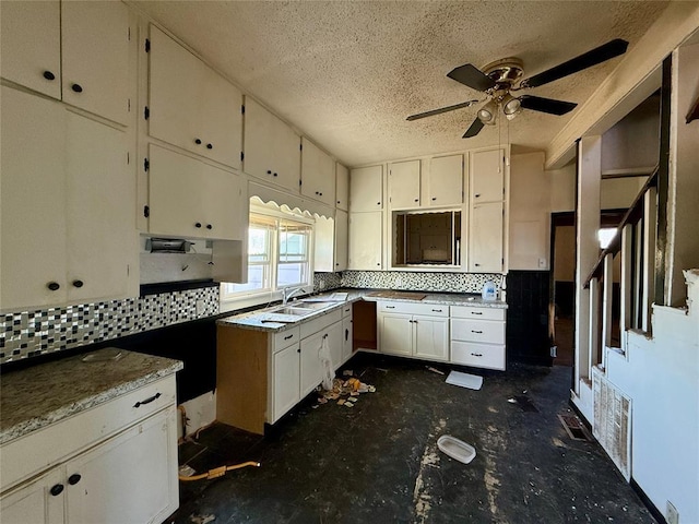 kitchen with white cabinets, ceiling fan, backsplash, and sink