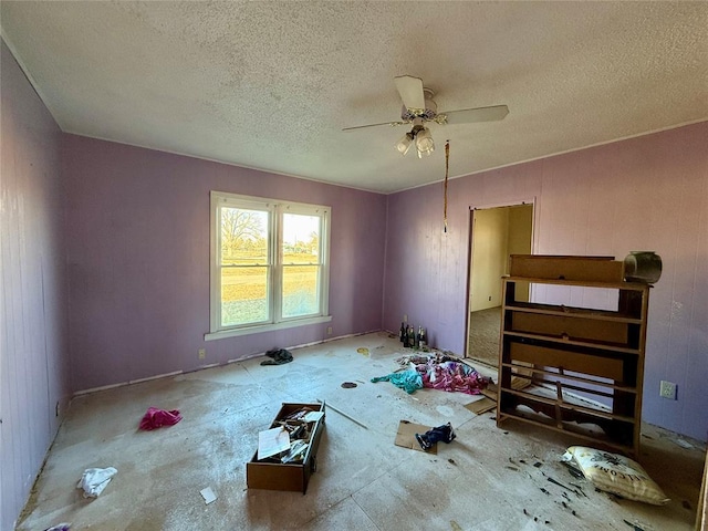 interior space with ceiling fan and a textured ceiling