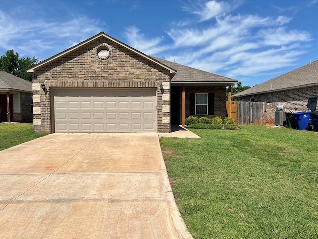 view of front of home featuring a garage, a front yard, and central AC